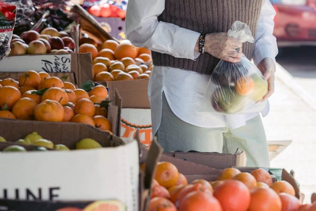 A customer with a bag of citrus fruits from a market.
