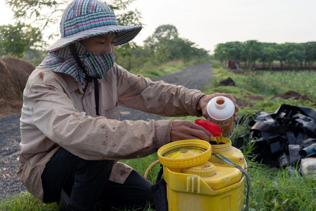 A farmer measuring a liquid plant protection product and pouring it into a tank
